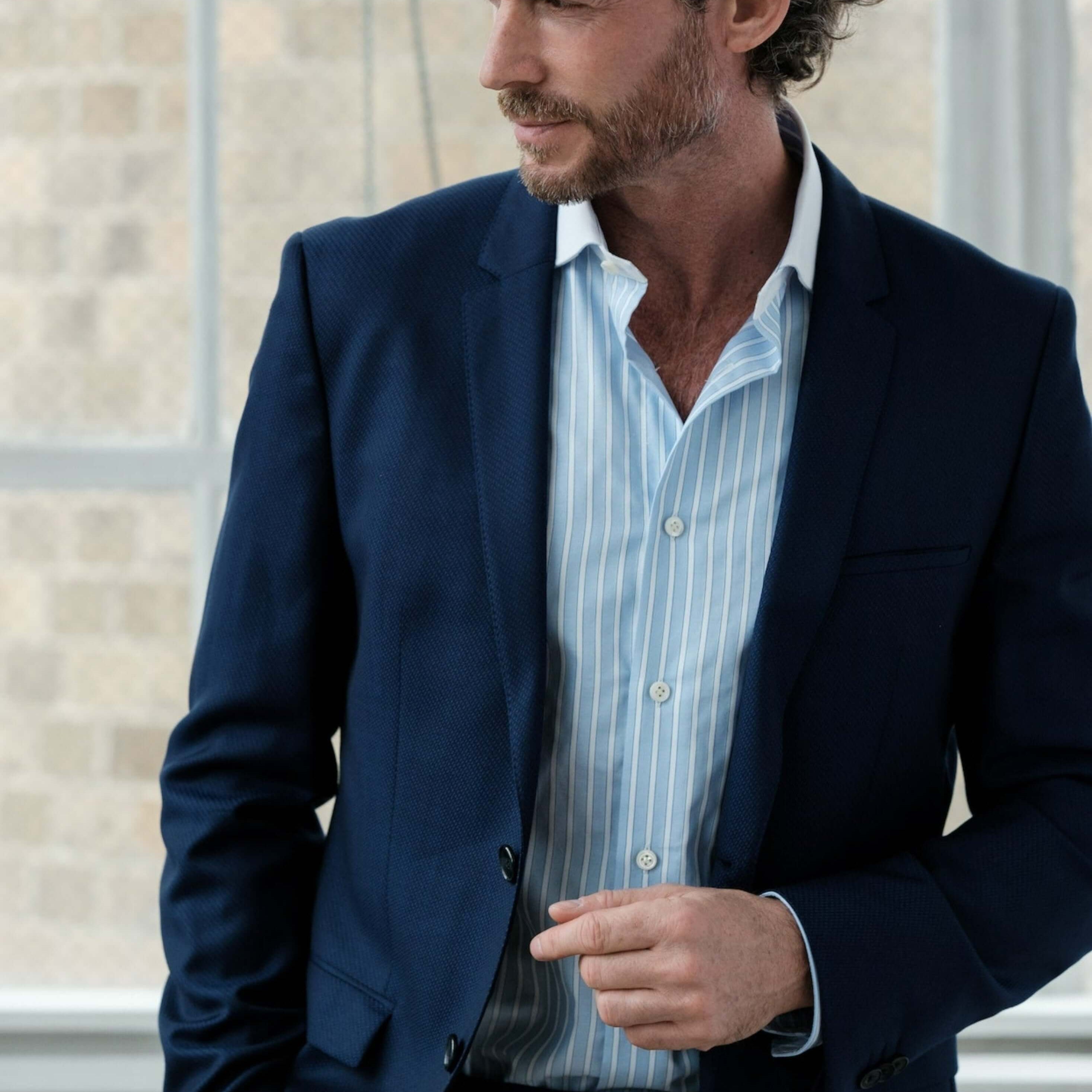 Man wearing Hester Luxury Men's Striped Dress Shirt – Blue | Treffort, displaying elegance and style in a formal setting.